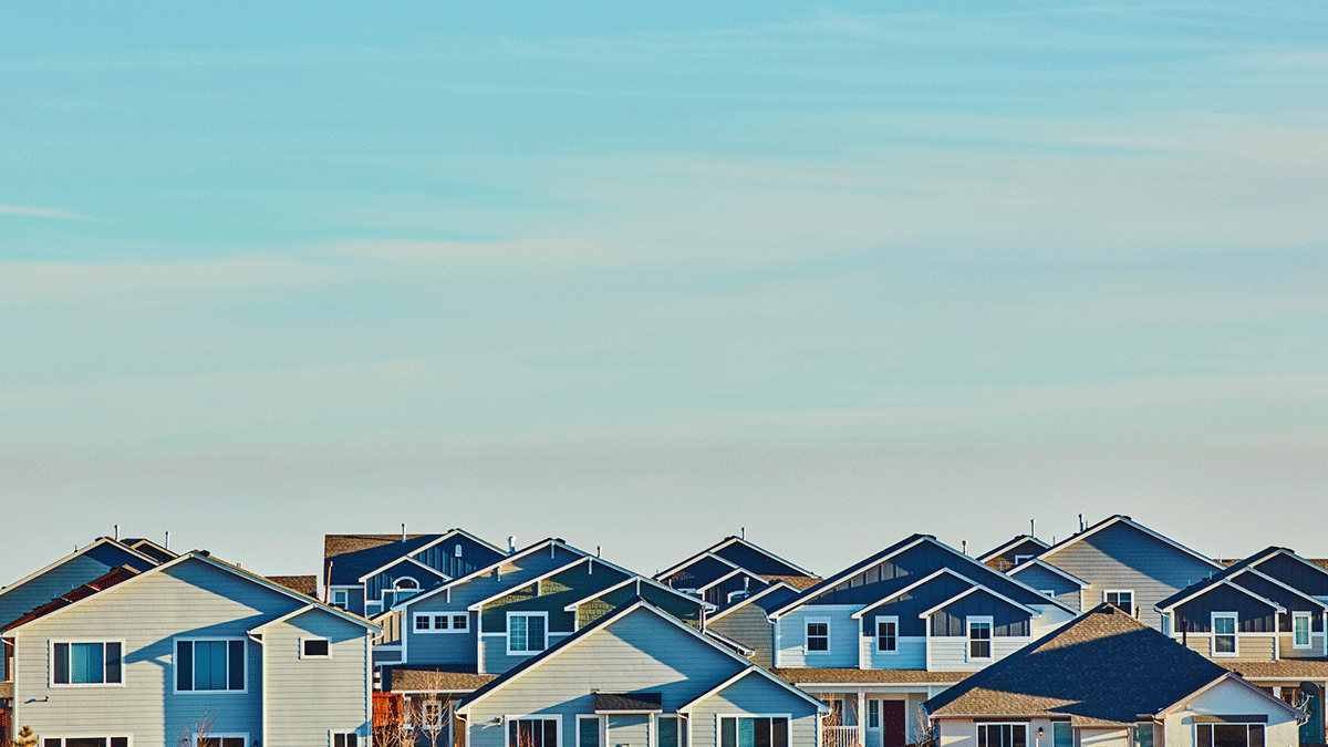 rooflines of houses with blue sky above